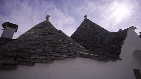 conical roofs of whitewashed stone huts known as trulli in alberobello, italy - low angle shot