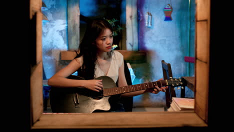 Chica-Asiática-Tocando-La-Guitarra-En-La-Ventana,-Estática.