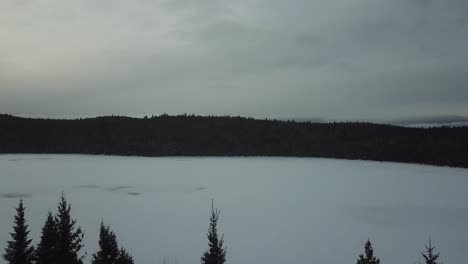 Vasto-Lago-Congelado-árboles-Invernales-Al-Lado-De-La-Carretera-En-Canadá-Lago-Congelado