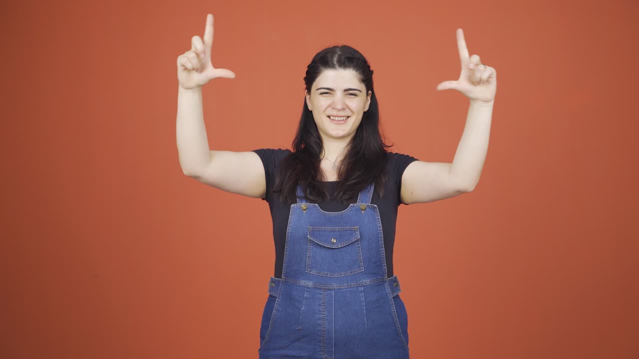 mujer haciendo una señal de corazón a la cámara.