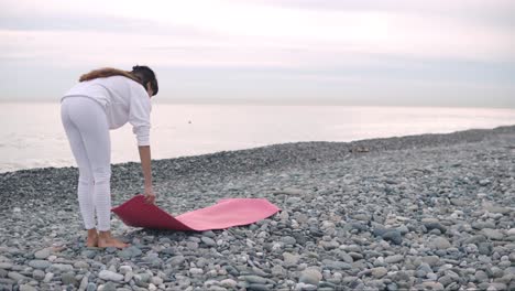 woman practicing yoga on a beach