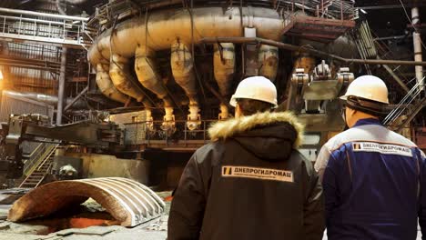 factory workers inspecting industrial machinery