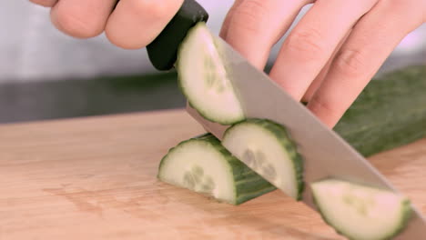 person cutting a cucumber in slow motion