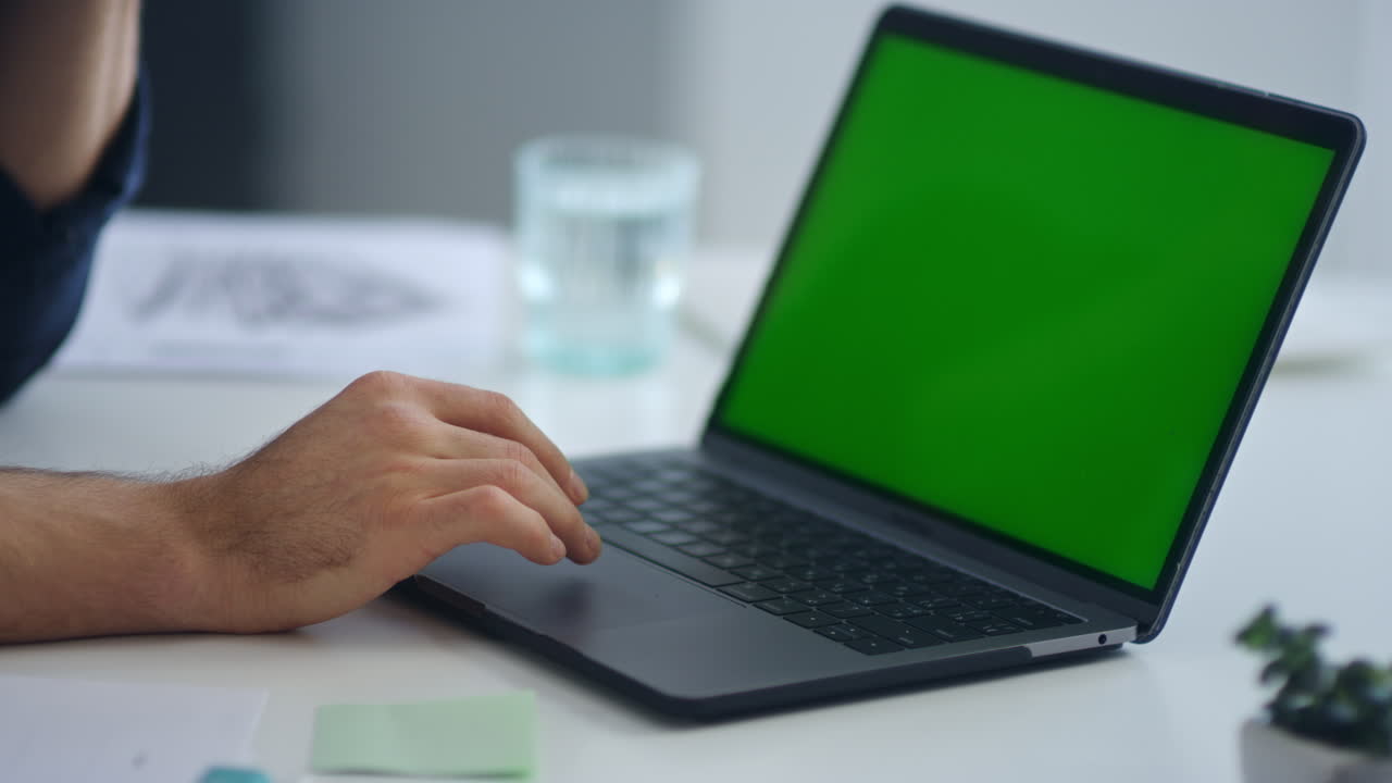 Man typing on laptop with green screen. Business man hands surfing internet.