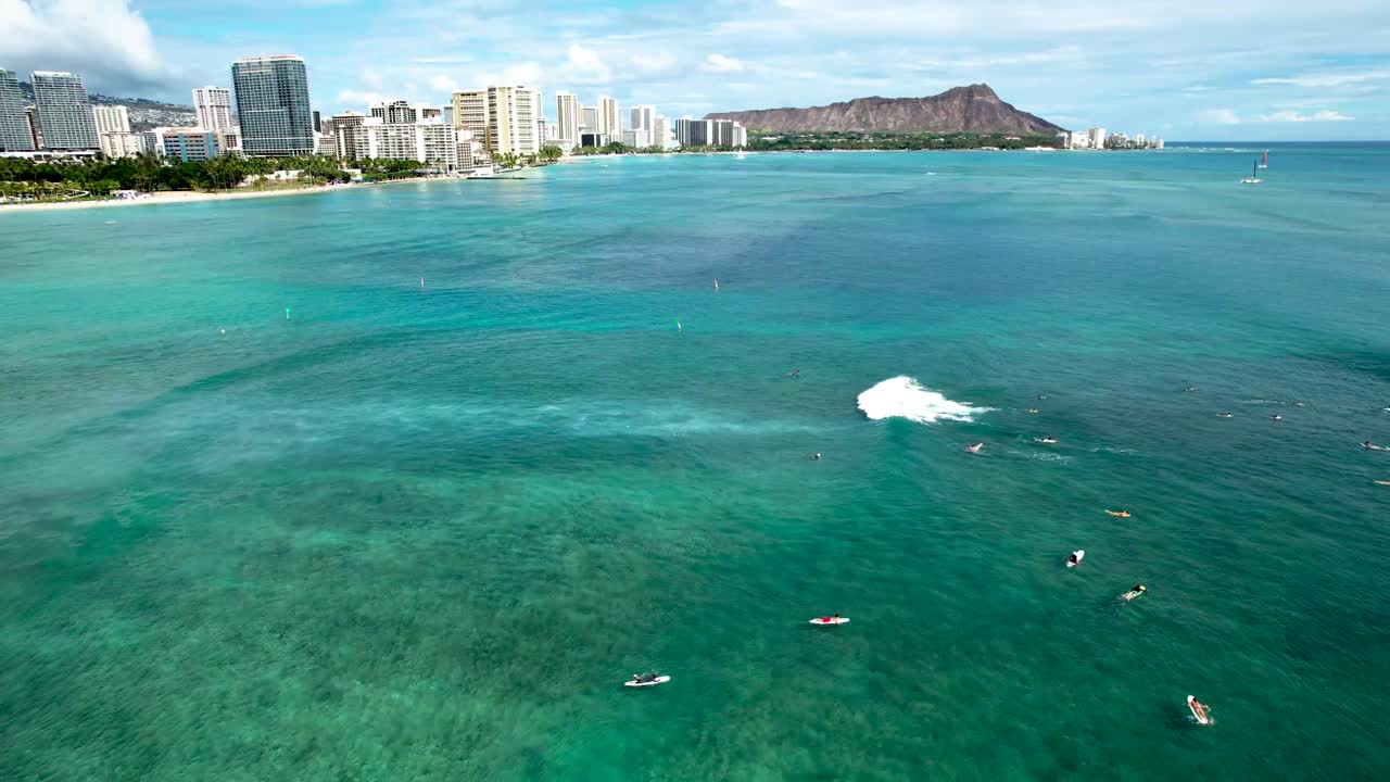다이아몬드 헤드와 와이키키 스카이라인을 배경으로 하와이에서 파도를 기다리는 서퍼