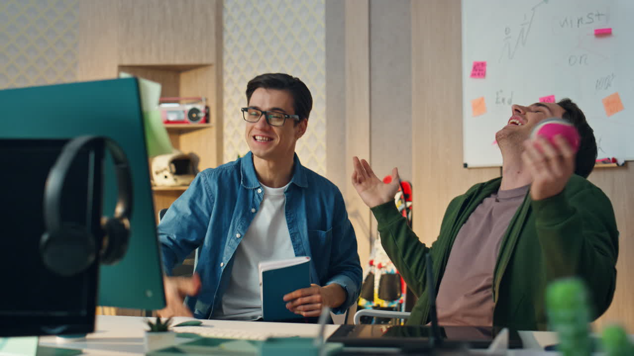 흥분한 창작가들이 비디오 통화를 하고, 컴퓨터 사무실에서 가까운 사진을 찍고, 동료들이 웃고 있다.
