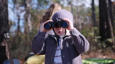a young boy keenly enjoys his outdoor exploration with colorful binoculars while being surrounded by a young boy keenly enjoys his outdoor exploration with colorful binoculars while being surrounded by nature