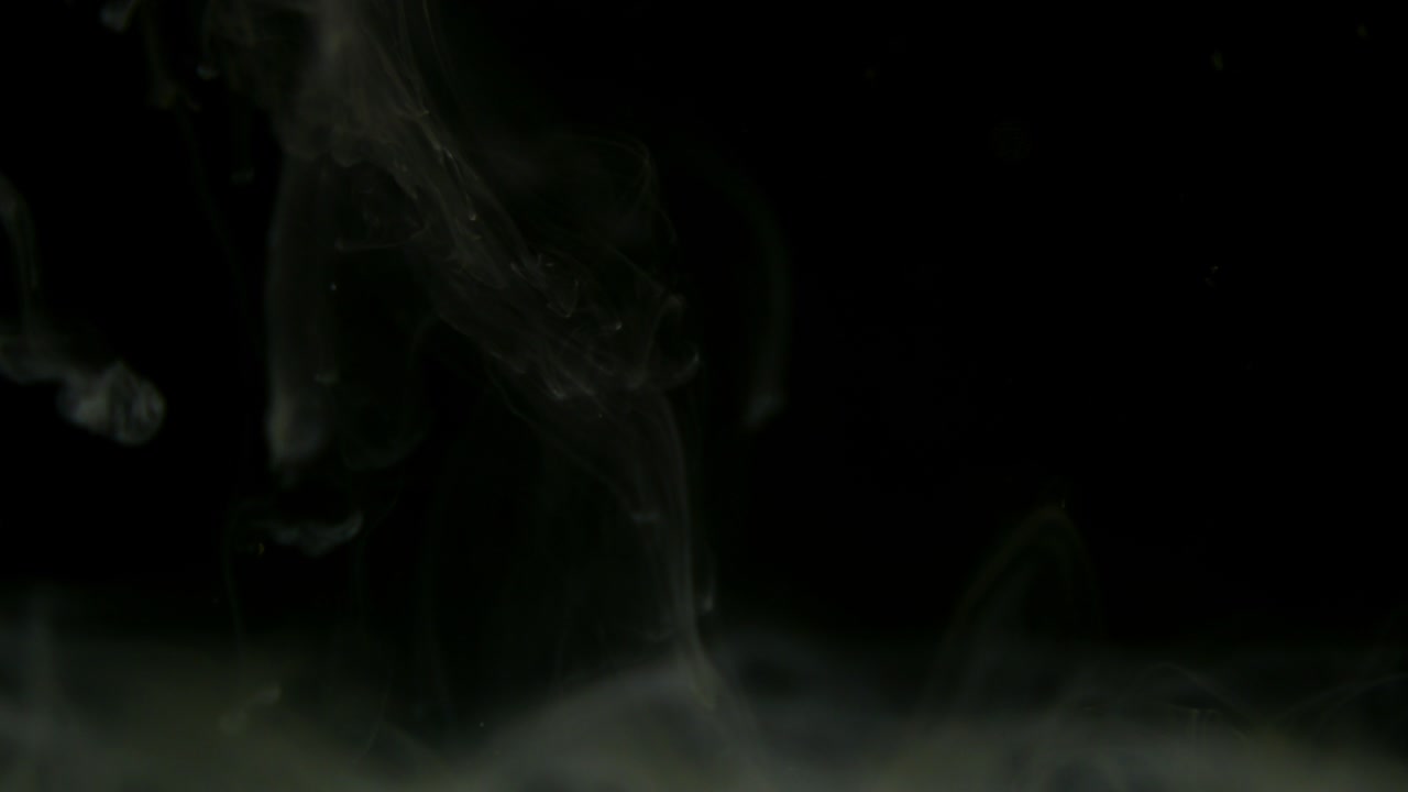 белый дым капли краски смешиваются в воде. чернила вращаются под водой. цветное акриловое облако абстрактный дым взрыв. близкий вид