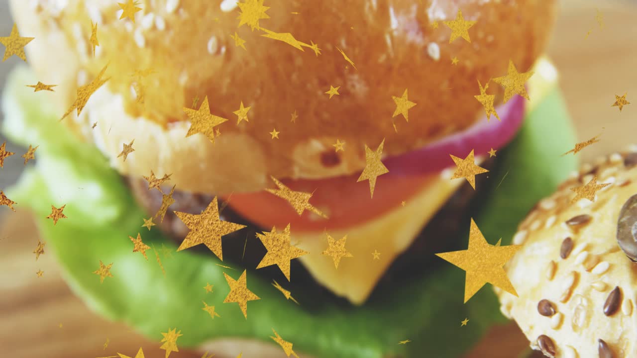 Estrelas douradas cintilando, a câmera se afastando e fazendo uma panorâmica, revelando um hambúrguer em pão com gergelim, exibindo o sanduíche.