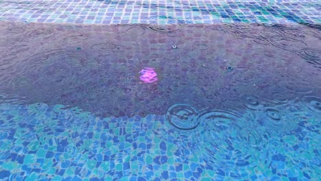 Falling-Raindrops-on-Water-Surface-of-Blue-Tiled-Pool-on-Rainy-Day-in-Thailand