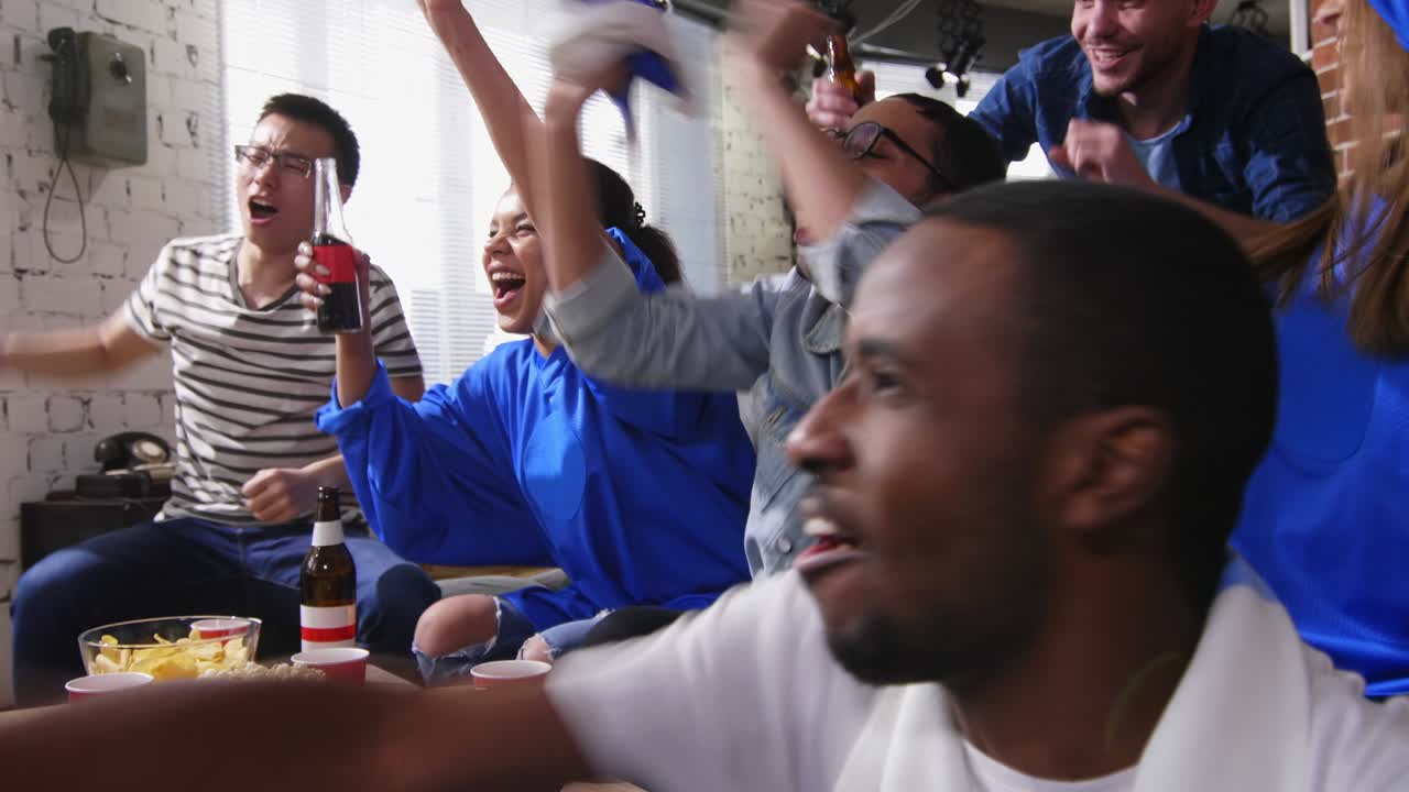 amigos viendo partidos en la televisión en casa.