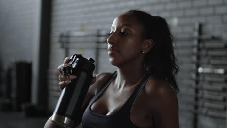 mujer bebiendo agua en el gimnasio