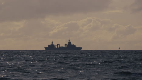 navy warship patrolling the coastline on a cold cloudy dull day