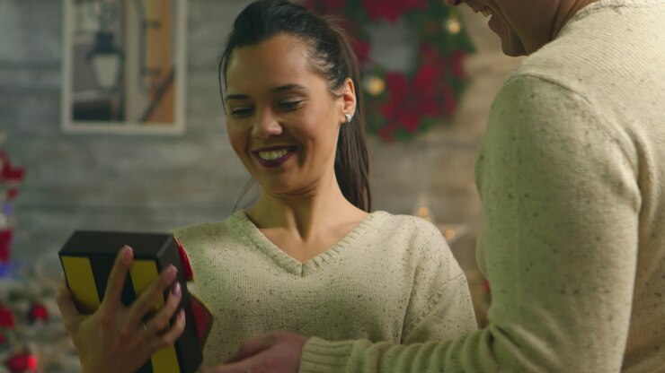 Romantic young man surprising his girlfriend on christmas day