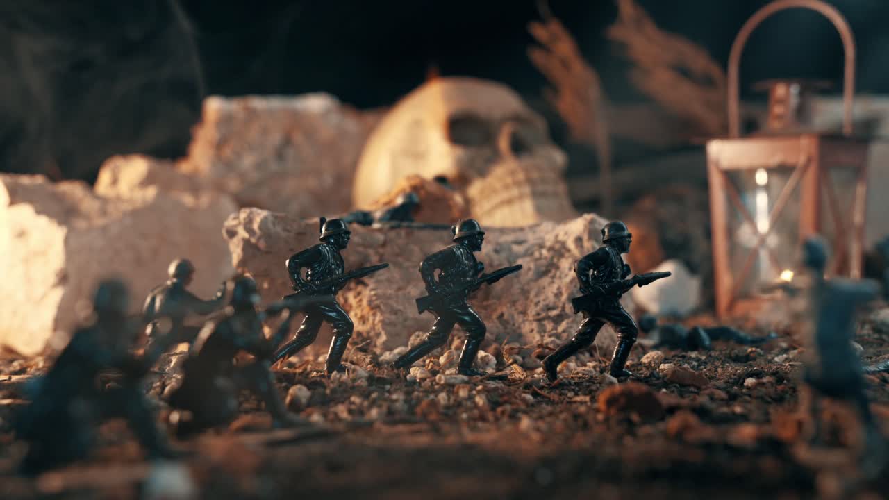 Soldatini di plastica in miniatura che combattono in un diorama di guerra. Una drammatica scena di battaglia con soldati giocattolo, un teschio e una lanterna in un paesaggio roccioso.