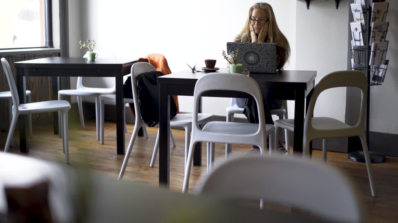 카페에서 노트북을 쓰고 있는 여자