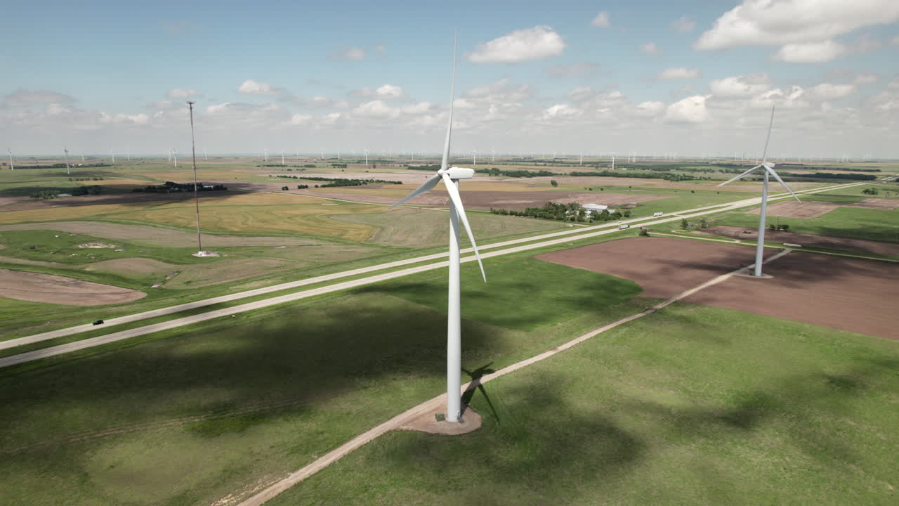 Aerial static view of state highway running through large wind turbine farm.
