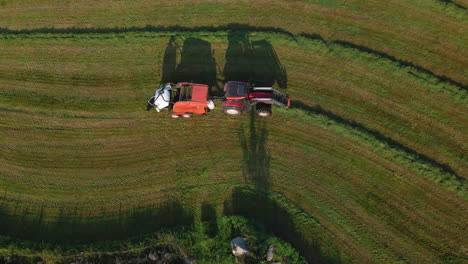 top view of a baler pulled by tractor making bale on a farm