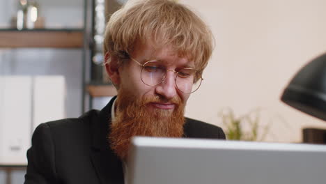 Close-up-businessman-freelancer-at-office-workplace-working-on-laptop-computer-sends-online-messages