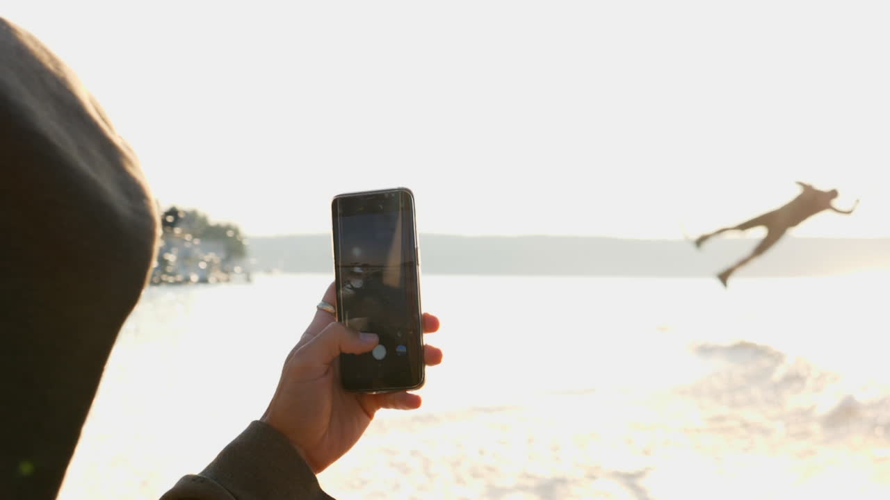 fotógrafo de alta clave con películas de iphone wakeboarder saltando sobre la ola