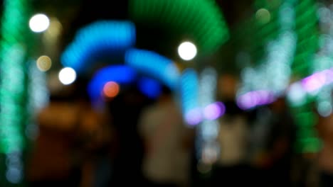 gente caminando por la calle por la noche fondo, túnel de borroso colorido bokeh luz desfocado fondo y textura para navidad