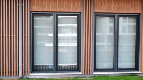 exterior de edificio moderno con puertas de vidrio deslizantes y revestimiento de madera