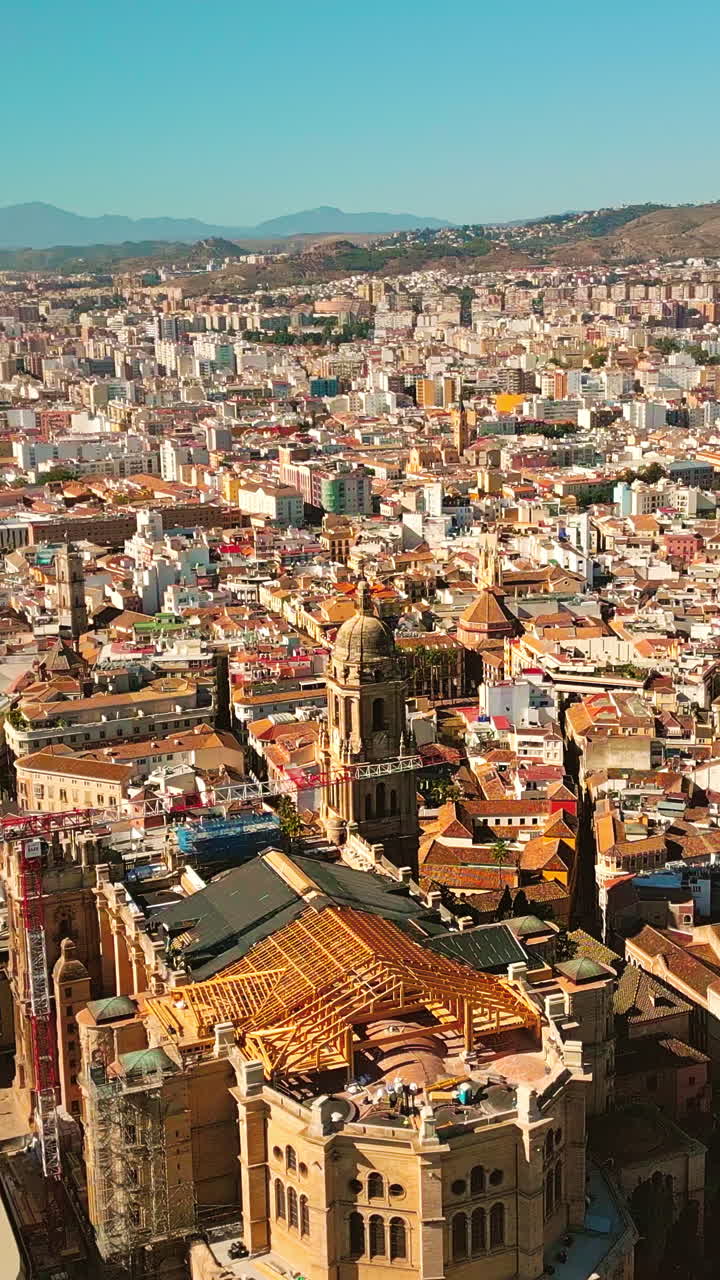 Vertikal dronekredsning omkring Málaga Katedral, gotisk arkitektur i det historiske centrum, middelhavs bybillede i klart dagslys, Spanien