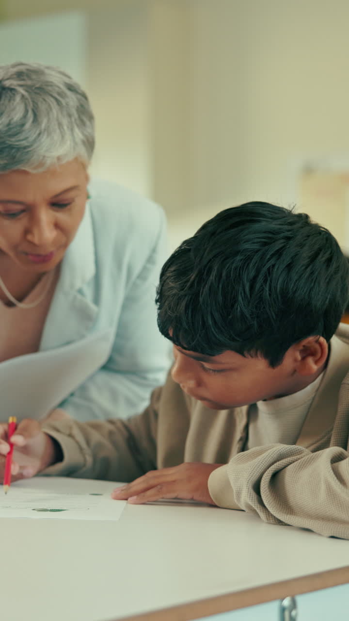 Teacher Assisting Young Boy with His Schoolwork
