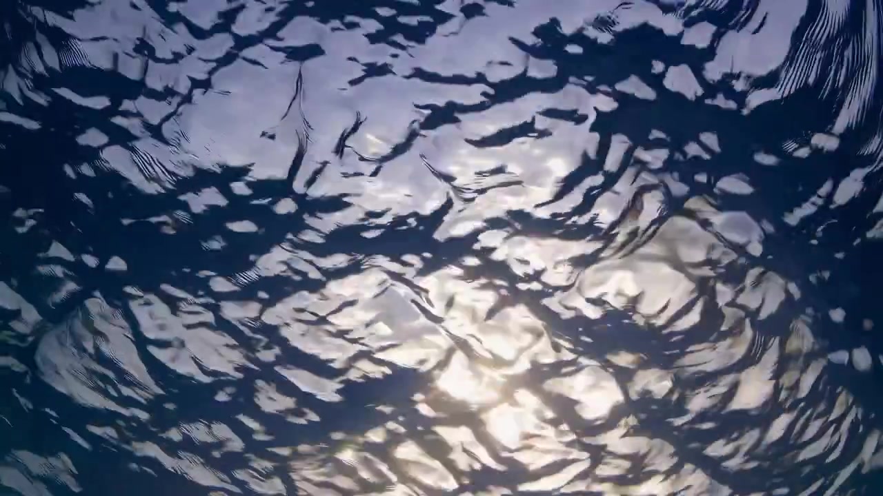 Luce solare che si rifrange attraverso la superficie increspata dell'oceano vista da sott'acqua