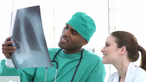 Ethnic-surgeon-showing-Xray-to-his-colleague