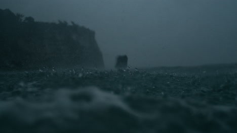 Shallow focus captures rainfall scattering across stormy ocean under clouds