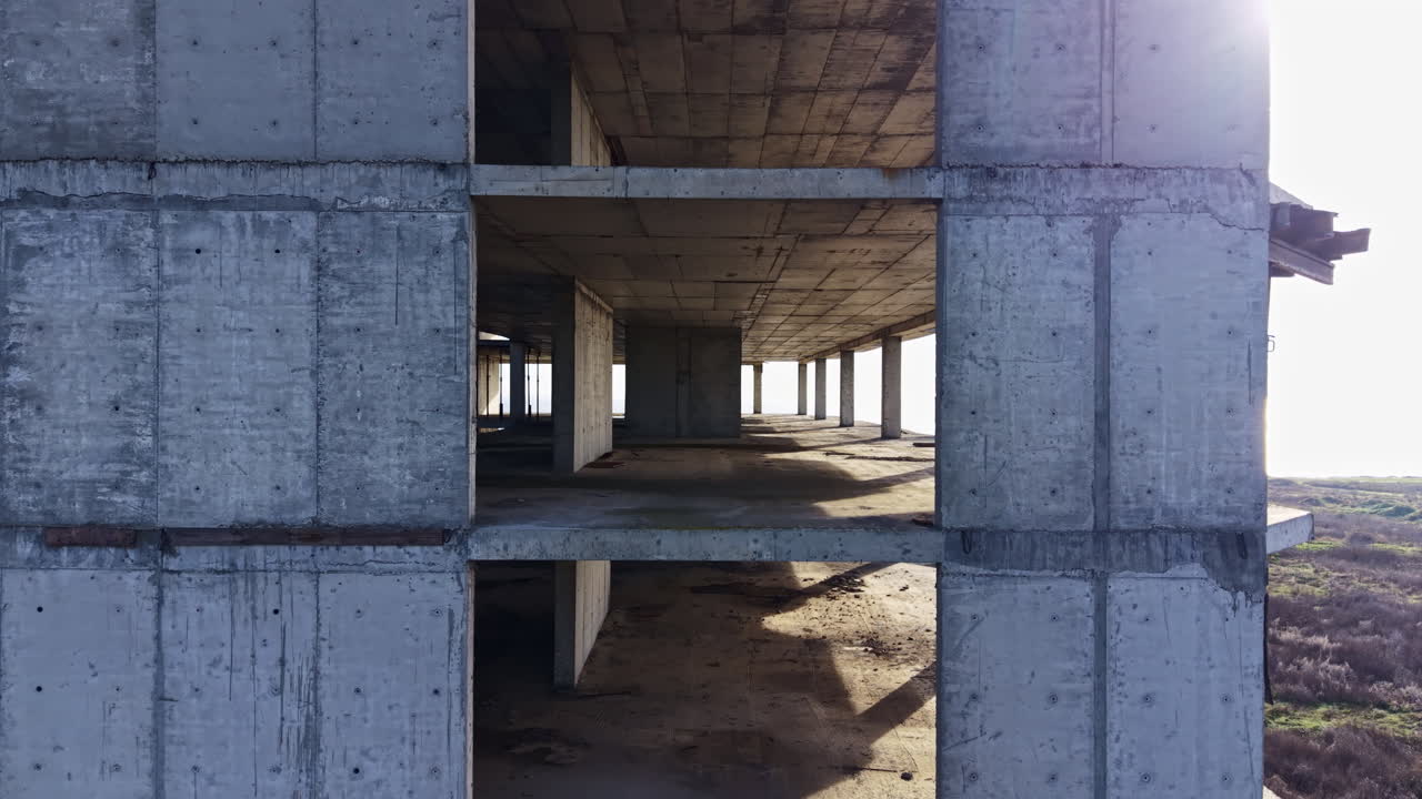 Unfinished concrete structure overlooking the sea at sunset reveals the beauty of urban decay and nature's serenity