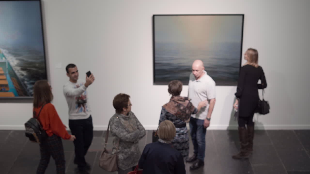 Couple taking selfie at art exhibition opening.