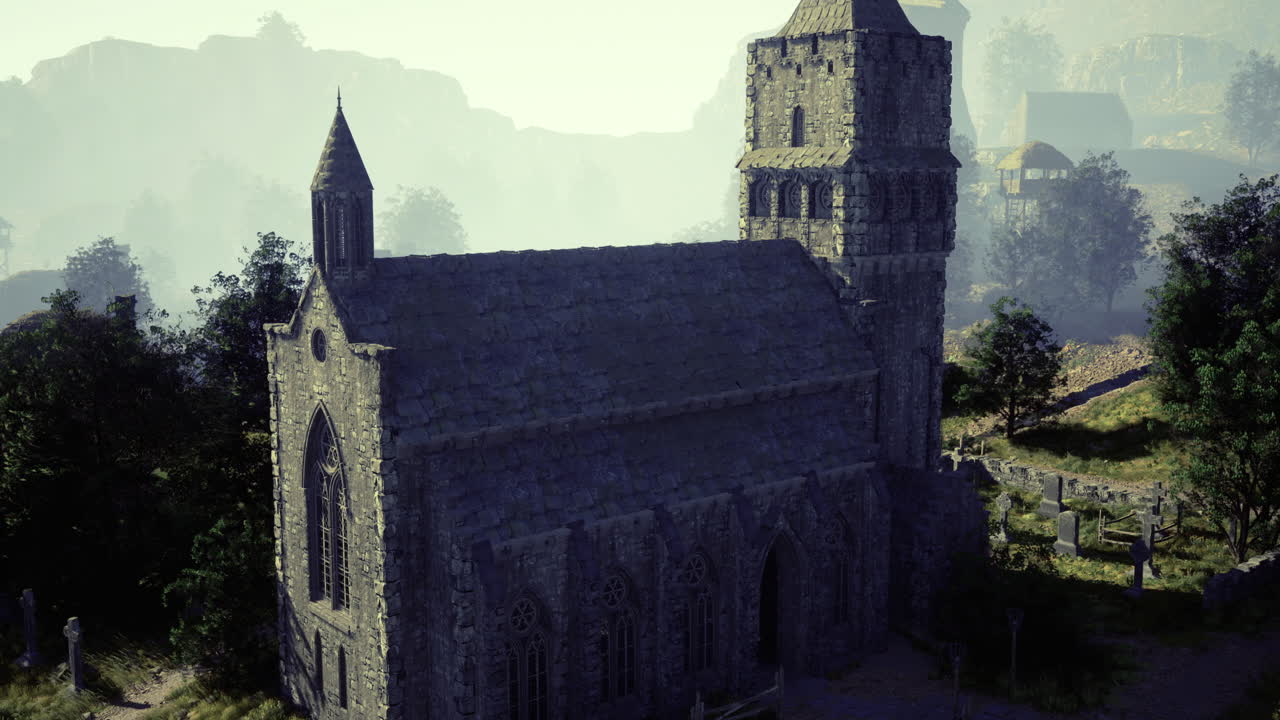 Historic stone church surrounded by lush greenery and mountains in daylight