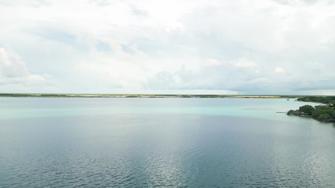 Aerial view of Bacalar Lagoon in Quintana Roo, Mexico. Crystal blue waters, green vegetation, and tropical scenery highlight this scenic and peaceful freshwater lake landscape