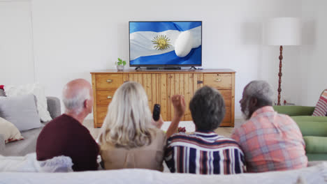 Verschiedene-ältere-Freunde-Schauen-Fern-Und-Haben-Einen-Rugbyball-Auf-Der-Argentinischen-Flagge-Auf-Dem-Bildschirm