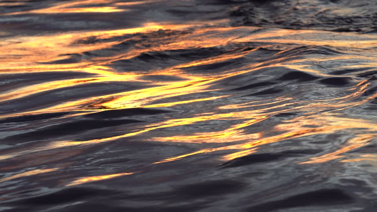 Ocean waves in evening at sunset with bright reflections