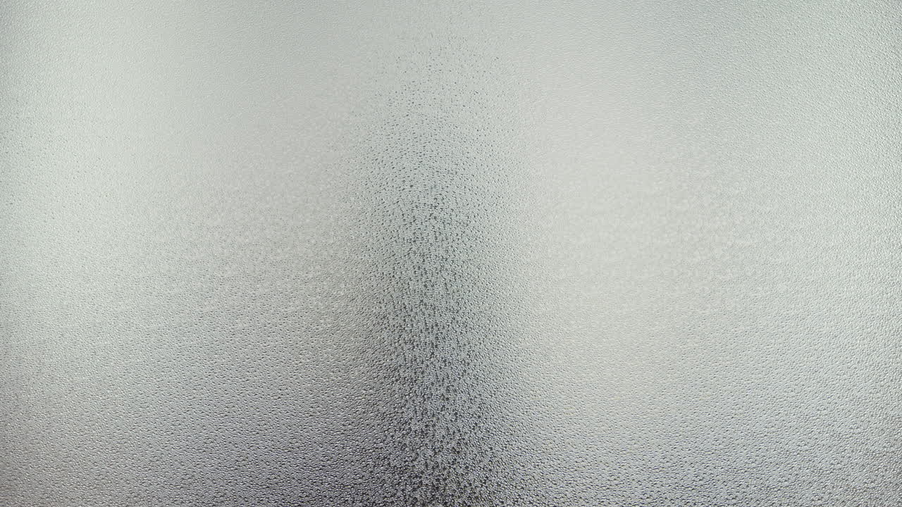 A female silhouette behind the frosted window dances slowly
