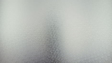 a female silhouette behind the frosted window dances slowly