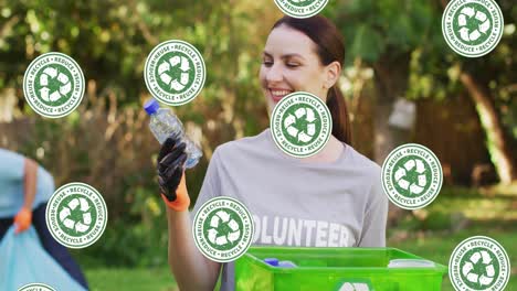 video de iconos de reciclaje cayendo sobre una feliz mujer caucásica recogiendo basura en el campo