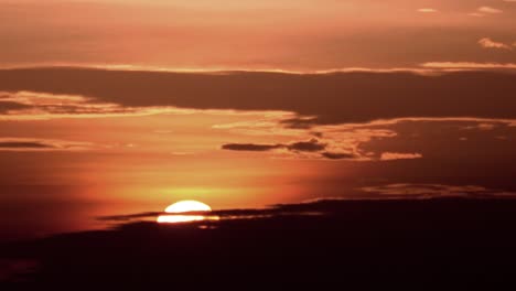 Wunderschöne-Orangefarbene-Sonne,-Die-Hinter-Den-Wolken-Untergeht