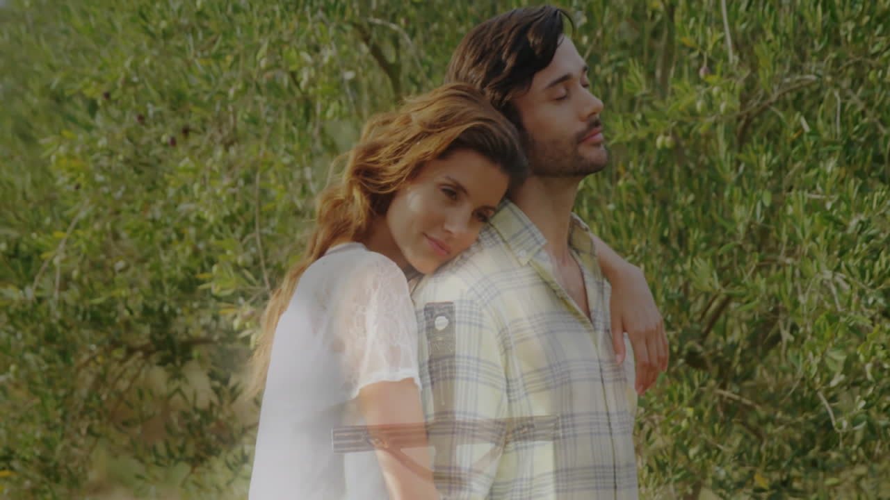 Couple embracing in olive grove for health campaign, with floating heart icon graphic