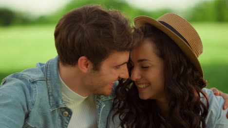 Cute-couple-sitting-on-meadow.-Happy-man-and-woman-laughing-outdoors