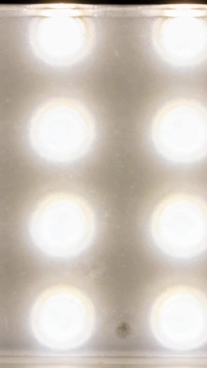 Vertical video: Recording vanity panel emitting glow at vanity for makeup, six bulbs, back, speck