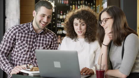 amigos colaborando en las computadoras portátiles en