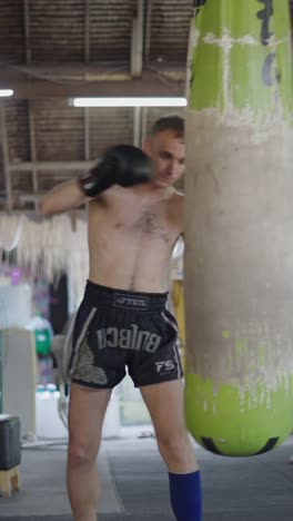 man training muay thai with a punching bag
