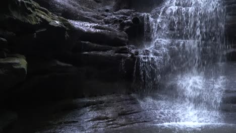 waterfall cascading down the mossy rock cliff side in matthiessen state park in illinois.