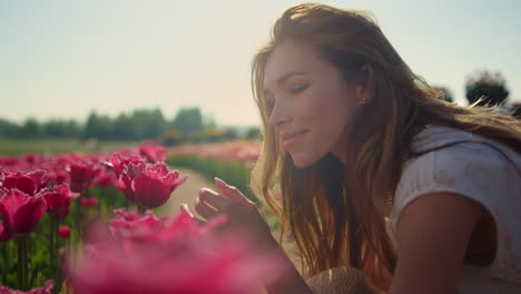 emotional girl smelling flowers in sunset light. beautiful woman enjoying flower