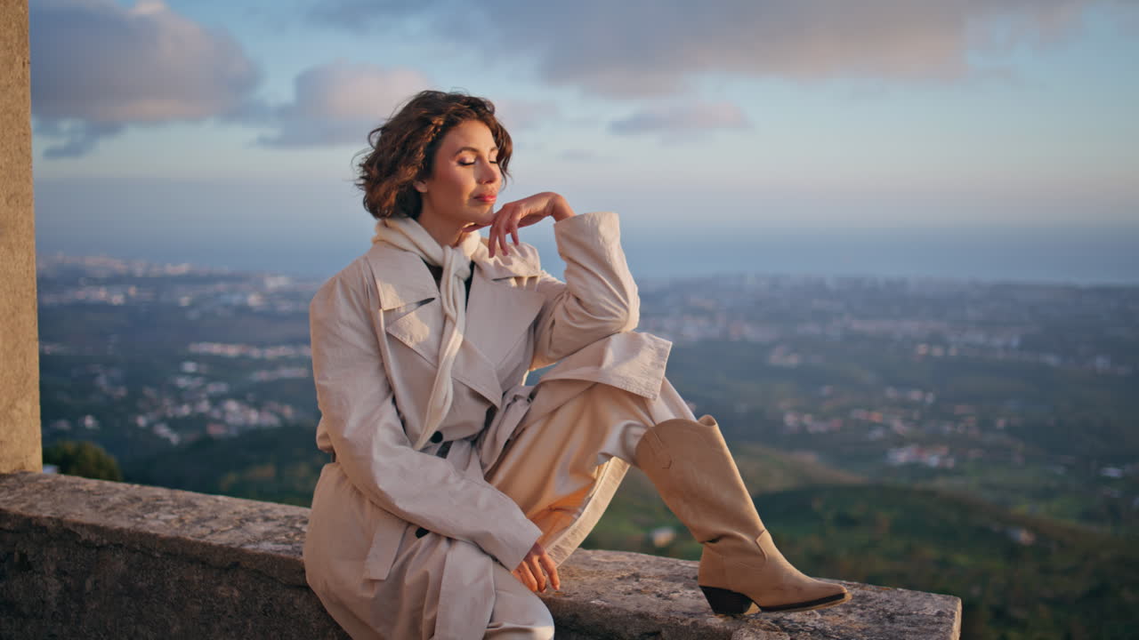Lady posing cityscape backdrop at windy evening. Stylish woman traveler weekend