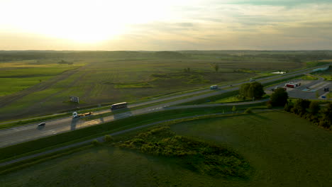 golden hour light over highway and rolling green fields